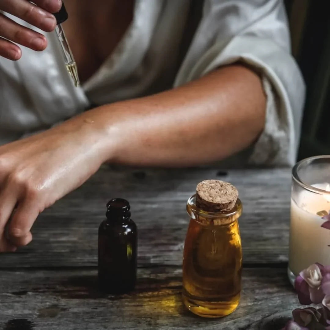 Sukime's Moringa Seed oil for oily skin, applying oil dropper to woman's arm on old wood table